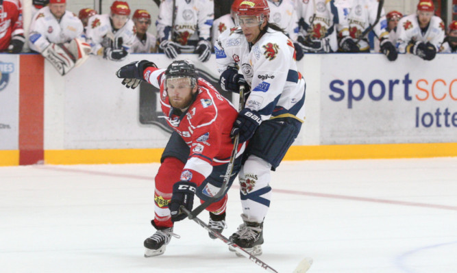 Doug Clarkson battles for the puck with Capitals Craig McCallum.