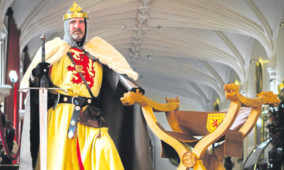 Brian McCutcheon, as Robert the Bruce, alongside the throne.