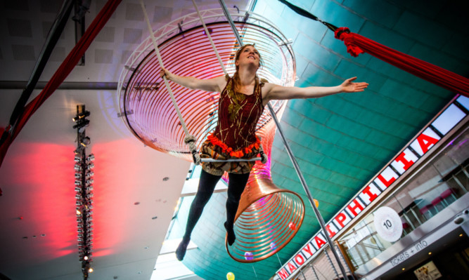 Lucy Power of aerial dance theatre company All or Nothing performs in the concert hall foyer.