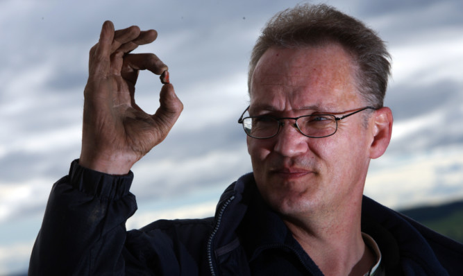 Volunteer Mark Anderson with piece of flint that was found during the dig.