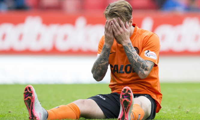 Dejection for United's Adam Taggart at loss to St Johnstone.