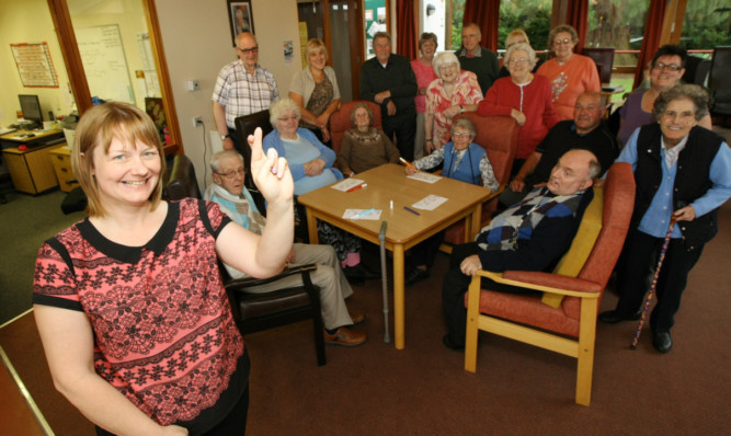 Kathleen Fotheringham, joined by staff and centre users, is hoping that the centre wins The Courier minibus competition.