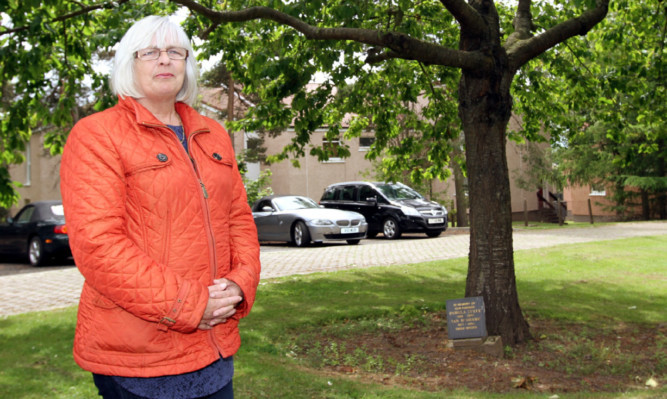 Isobel Tully beside the memorial tree.