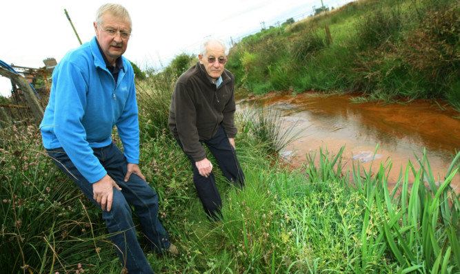 Resident Robert Bennett, left, and David Taylor by a contaminated ditch.