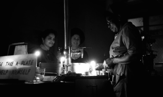 Serving tea by candlelight in a Ludgate Circus cafeteria during a power cut under the power saving measures resulting from the miners strike in 1972.