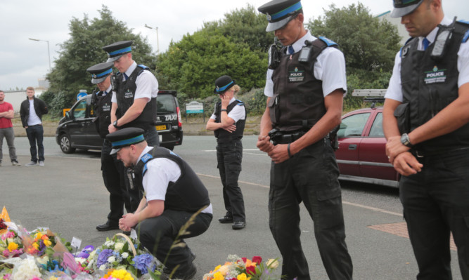 Police officers lay flower tributes in Wallasey, Merseyside.