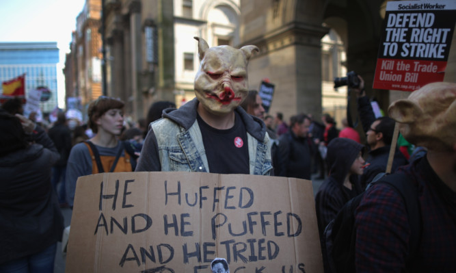 A masked protester outside the Conservative Party conference in Manchester