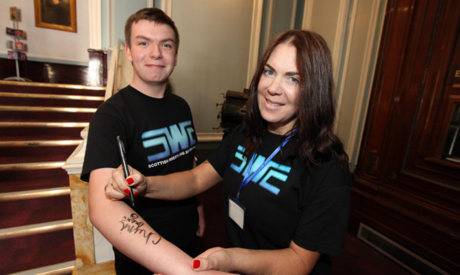 Chyna signs an autogrpah for 16-year- old Callum Nicoll
 during her appearance at the Caird Hall.