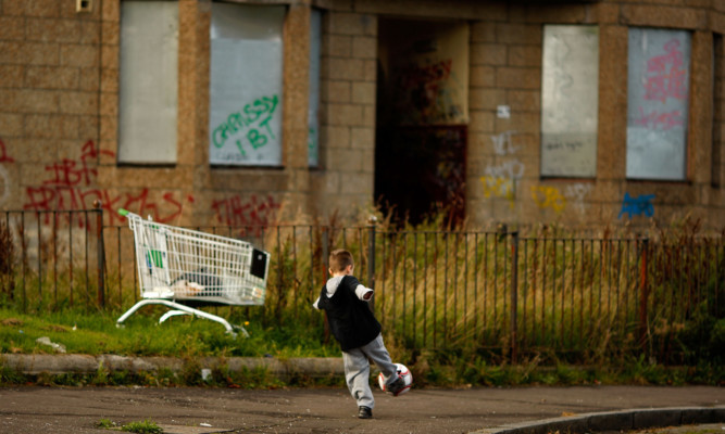 Two young boys play football in a street in Govan on September 30, 2008 in Glasgow, Scotland. Latest reports by the campaign to end child poverty, claim that millions of children are living in households living on under  £10 per person per day.