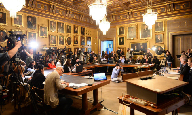 Journalists and press photographers gather at the Royal Swedish Academy of Sciences.