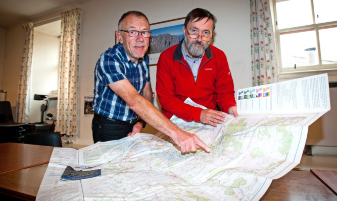 From left: David Gibson and right Neil Reid , from the Mountaineering Council of Scotland examining a map for the site of the controversial windfarm at Dulater Hill near Butterstone.