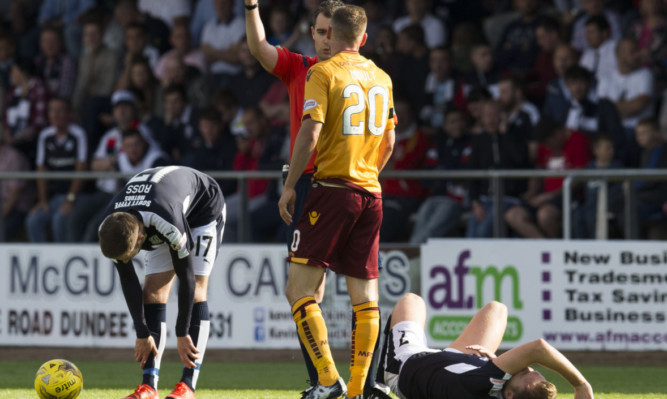 Greg Stewart (right, grounded) lies in agony after Louis Moult's foul.