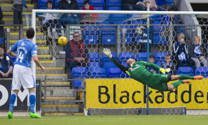 Alan Mannus tries to stop Steven Lawless's strike from finding the net.
