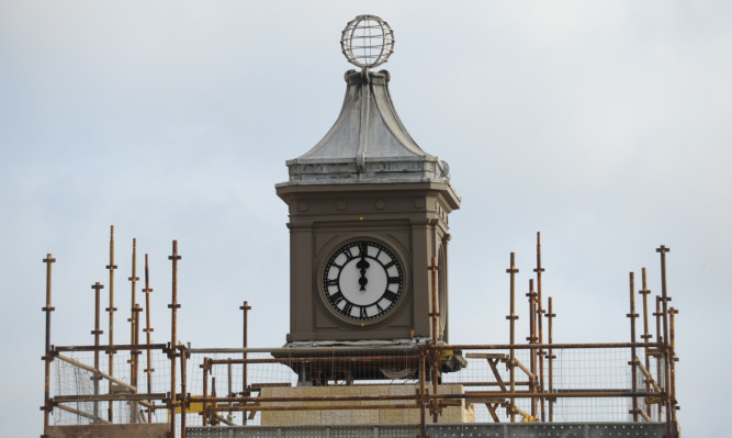 The refurbished clock tower emerges from scaffolding as work continues on the new Harris Academy in the citys West End.