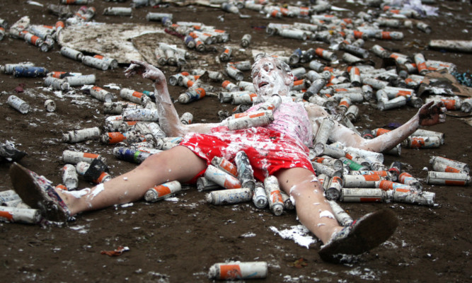 A reveller lies amid the debris of the Raisin Weekend foam party.