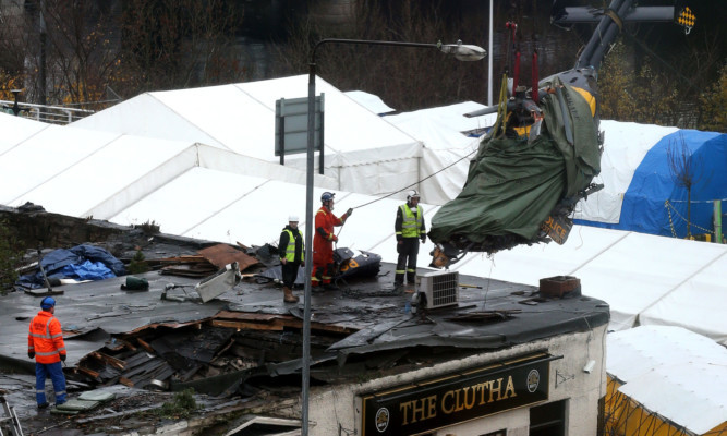 The helicopter wreckage being lifted out of the Clutha pub.