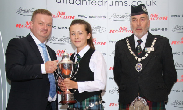 Nigel Hodgen, Andante Drums, presents Chloe with her trophy watched by George Usher, RSPBA president.