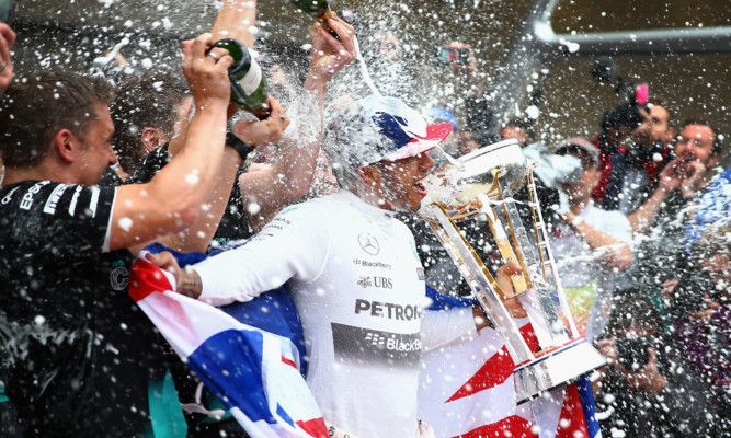 Lewis Hamilton celebrates with the Mercedes GP team.