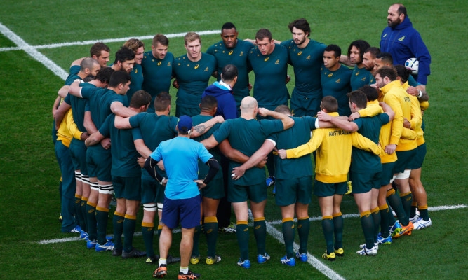 Michael Cheika (centre) delivers the final team talk that led Australia to victory over Argentina.