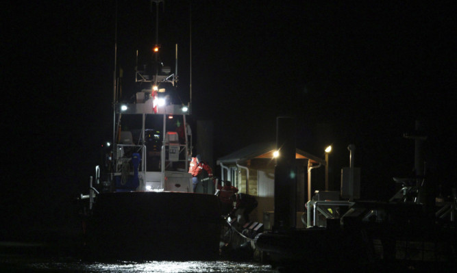 Canadian Coast Guard crew arrive at a dock in Tofino following a search and rescue operation.