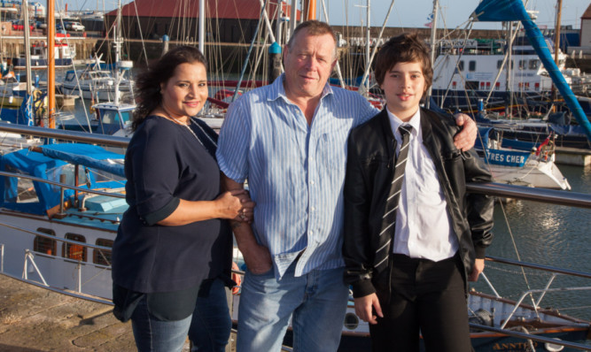 Parents Sunita and Bill Adam with Cameron.