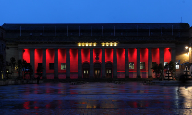 The Caird Hall bathed in red light.