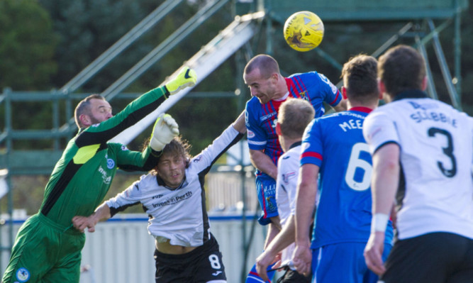 Alan Mannus in the thick of the action at Inverness.