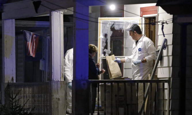 Members of the FBI evidence team remove items from the house.