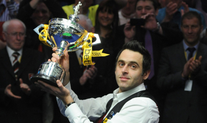 Ronnie O'Sullivan celebrates with the trophy.