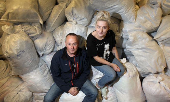 Mike Strachan and Sammi Craig with just some of the mountains of donations.