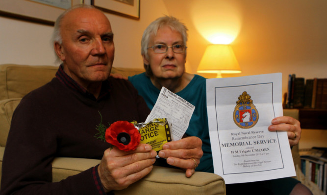 Ron and Meg Woomble with the parking charge notice they received while they were attending a Rememberance Service on board the Unicorn.