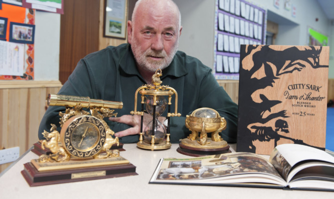 Dave Ramsay with some of the auction items for the memorial dinner later this month.