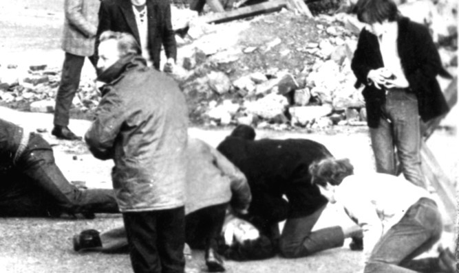 A man receives attention during the shooting, which became known as Bloody Sunday.