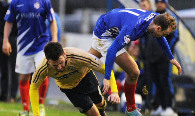 Brechin City defender Paul McLean sends Cowdens Greig Spence flying.