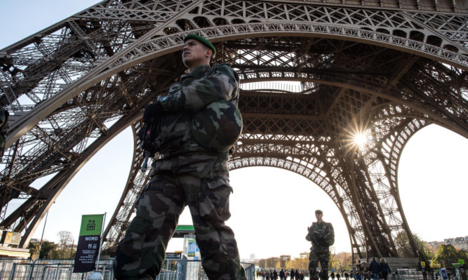 A French soldier stands guard at Eiffel Tower.
