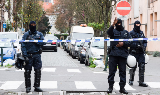 A major action with heavily armed police took place in the Brussels neighborhood of Molenbeek amid a manhunt for a suspect of the Paris attacks.