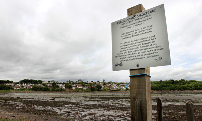 Signs at Dalgety Bay warn the public to stay away from the area and not remove any items.