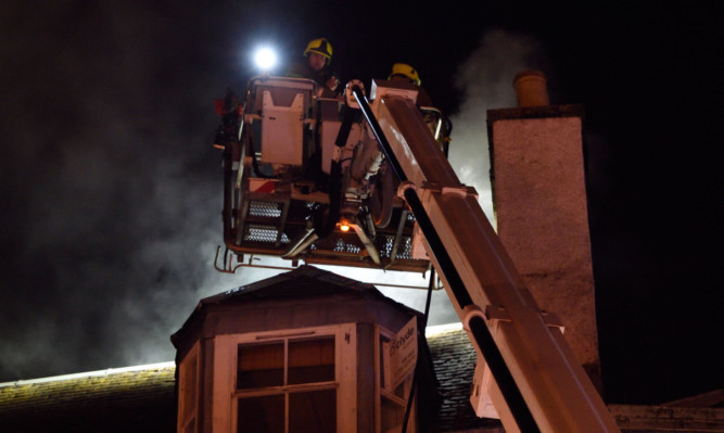 Firefighters using an aerial platform to examine the chimney. (Click arrow for more photos)