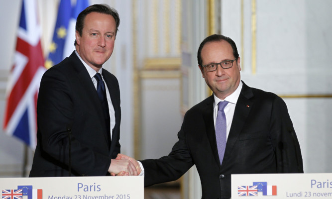 Prime Minister David Cameron shakes hands with French President Francois Hollande.