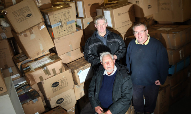 Raven Trust founder John Challis, local organiser David Randall and trustee Alan Lavarock with just a small part of the generous donations that will be loaded and shipped out to schools, homes and hospitals in Malawi.