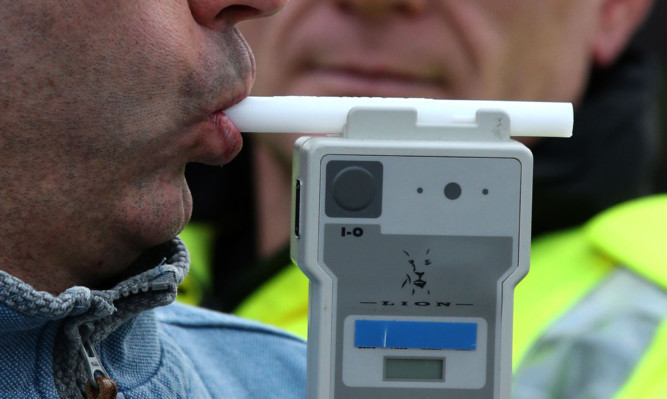 PICTURE POSED BY MODEL
Road Traffic constable John Parry from Police Scotland demonstrates breathalyser equipment at a drink-drive limit change awareness event at Lockerbie Police Station, Scotland, as the reduced drink-driving limit comes in to force at the end of this week.  ... Reduced drink drive limit ... 03-12-2014 ... Lockerbie ... UK ... Photo credit should read: Andrew Milligan/PA Wire. Unique Reference No. 21635129 ... Picture date: Wednesday December 3, 2014. The Scottish Parliament last month unanimously approved measures to reduce the legal limit from 80mg to 50mg per 100ml of blood with the change coming into force from Friday. See PA story SCOTLAND Alcohol. Photo credit should read: Andrew Milligan/PA Wire