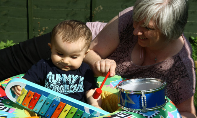 Jemma and Oliver with his drum and xylophone.