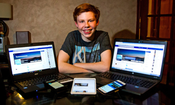 photo shows a younger Andrew Batchelor with laptop, tablet and mobile phone laid out in front of him.