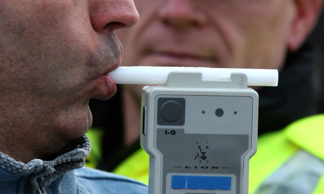 PICTURE POSED BY MODEL
Road Traffic constable John Parry from Police Scotland demonstrates breathalyser equipment at a drink-drive limit change awareness event at Lockerbie Police Station, Scotland, as the reduced drink-driving limit comes in to force at the end of this week.  ... Reduced drink drive limit ... 03-12-2014 ... Lockerbie ... UK ... Photo credit should read: Andrew Milligan/PA Wire. Unique Reference No. 21635129 ... Picture date: Wednesday December 3, 2014. The Scottish Parliament last month unanimously approved measures to reduce the legal limit from 80mg to 50mg per 100ml of blood with the change coming into force from Friday. See PA story SCOTLAND Alcohol. Photo credit should read: Andrew Milligan/PA Wire