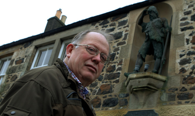 Largo community council secretary Stephen Wood at the statue which is the only link the village has with Defoe as the library remains under threat.