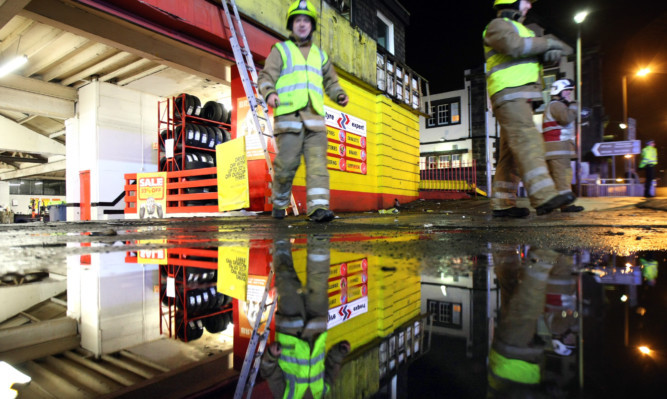 Parts of Fort Street and Queen Street in Broughty Ferry were cordoned off on Friday night after a 30ft section of sign was torn from National Tyres in high winds.