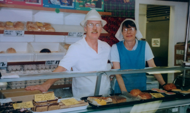 The McEwens behind the counter of their shop.