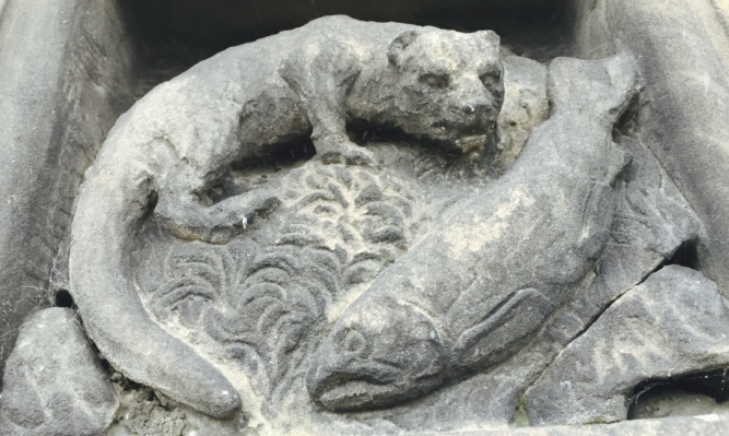 The carving of an otter and a salmon was discovered during conservation work.