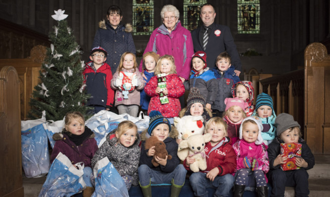 Staff and youngsters from Smallworld Nursery drop off their parcels to church elder Irene Gillies and Tesco Brechin store manager Paul Cassidy.