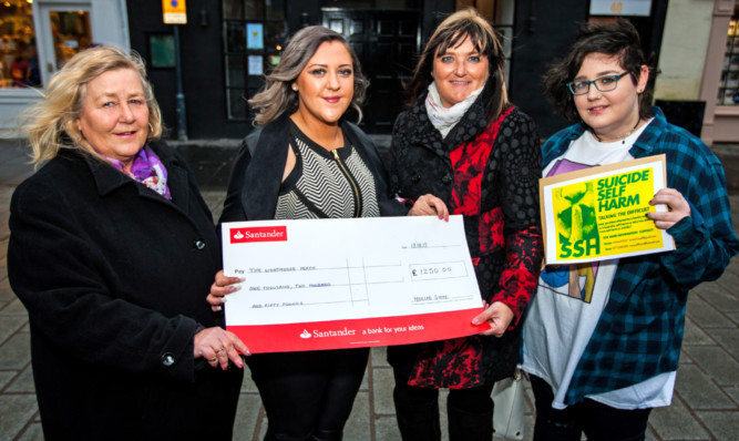 Hollie, centre left, presents a cheque for the £1250 raised at the ladies night to Tracy, centre right, along with Kirstie Howell, left, and Caitlin Hanna of the suicide and self-harm support group in Perth.